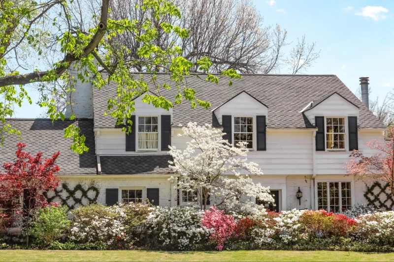 Traditional upscale home with dogwood tree and azelea bushes - beautifully landscaped in springtime